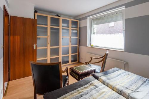 ein Schlafzimmer mit einem Bett, einem Stuhl und einem Fenster in der Unterkunft Ferienwohnung Schenefelder Drift in Schenefeld