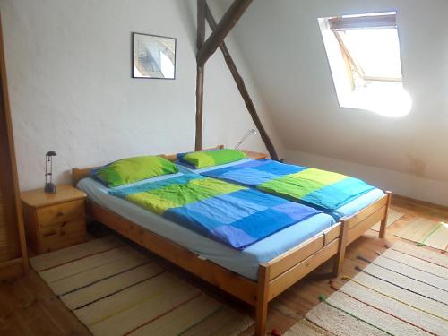a bedroom with a bed with a blue and green comforter at Ferienwohnung Bergfeld in Bergfeld
