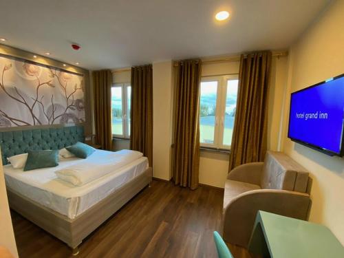ベルリンにあるHotel Grand Innのベッドルーム(ベッド1台、薄型テレビ付)