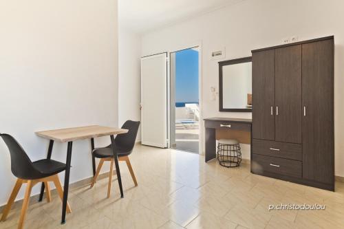 a room with a desk and a table and chairs at Albatros Studios & Apartments in Lefkos Karpathou