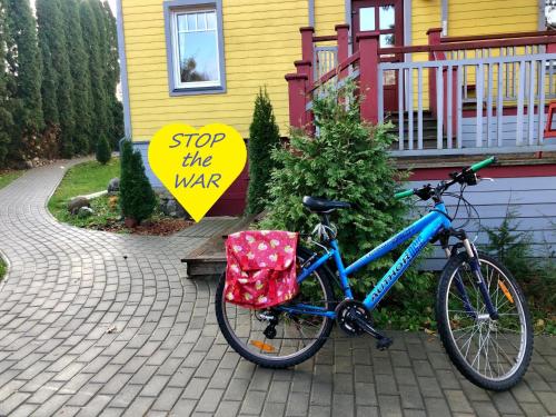 uma bicicleta estacionada em frente a uma casa com uma placa em Guest House Mr Fox em Druskininkai