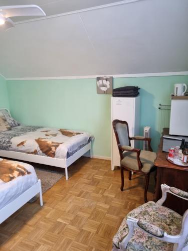 een kamer met 2 bedden, een bureau en een stoel bij Erbuca Bed and Breakfast in Nieuwstadt