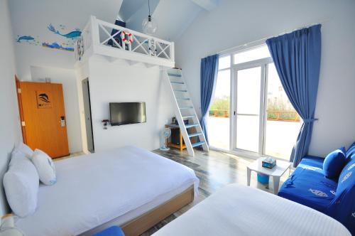 a small bedroom with two beds and a ladder at Sea Daughter's Homestay in Huxi