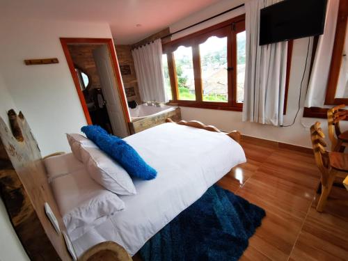 a bedroom with a white bed with blue pillows at Hospedaje Vista Hermosa Salento in Salento