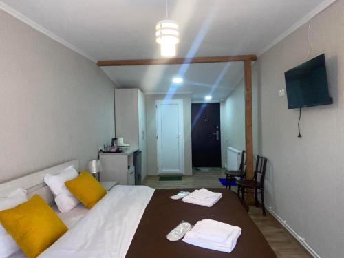 1 dormitorio con 1 cama con almohadas amarillas y TV en Jorjadze street 23, en Borjomi