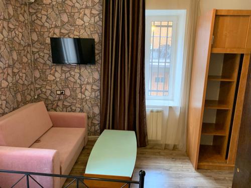 a living room with a couch and a tv on a wall at Shara Talyan 8/2 Guest House in Yerevan