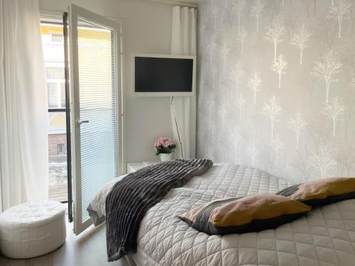 a bedroom with a bed and a tv on the wall at Modern 1 bedroom apartment in Central Kuopio in Kuopio