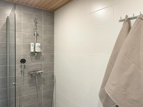 La salle de bains est pourvue d'une douche avec une porte en verre. dans l'établissement Modern 1 bedroom apartment in Central Kuopio, à Kuopio