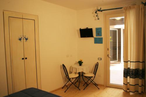 una pequeña mesa y sillas en una habitación con ventana en Note Sulla Piazza, en Cagliari