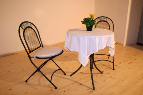 una mesa y dos sillas con una mesa blanca y una planta en Note Sulla Piazza, en Cagliari