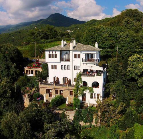 une grande maison blanche au sommet d'une colline dans l'établissement Archontiko Elda, à Ágios Dimítrios