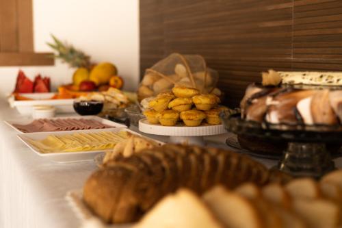a table topped with different types of bread and pastries at Pousada Buriti in Itaúnas