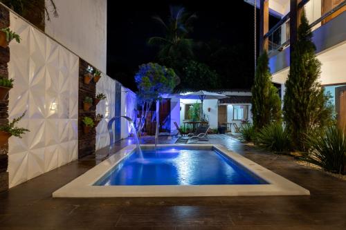 a swimming pool in the middle of a yard at night at Pousada Buriti in Itaúnas