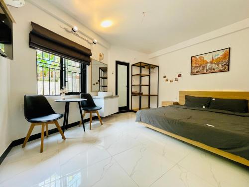 1 dormitorio con 1 cama, mesa y sillas en Robin House en Hue