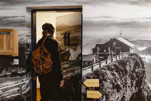 a woman standing in front of a poster of a mountain at Das Franzl - Bett & Brot in St. Wolfgang