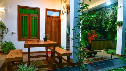 a house with a table and benches in front of it at Menara Green Inn in Dambulla