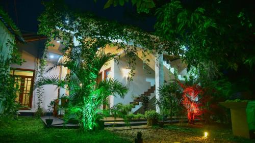 a house lit up at night with green lights at Menara Green Inn in Dambulla