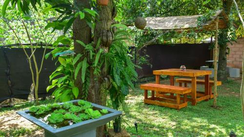a table and a bench next to a tree at Menara Green Inn in Dambulla