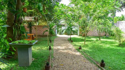 a garden with trees and a walk way at Menara Green Inn in Dambulla