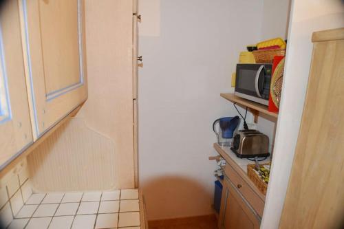 une petite cuisine avec un réfrigérateur et un micro-ondes dans l'établissement Bel appartement pour 6 personnes dans résidence avec piscine 500 m plage, à Cavalaire-sur-Mer