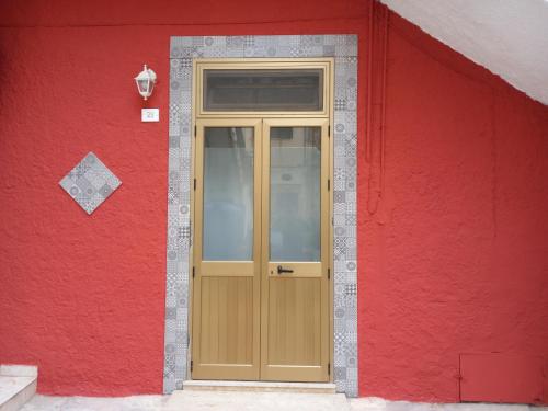 a red building with a wooden door on it at La Locanda in Marsala