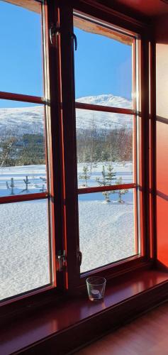 a window with a view of a snow covered field at Visit Junkerdal in Junkerdal