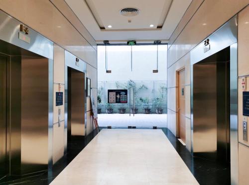 a hallway in a building with elevators and a window at Gold Coast Luxury Apartment Nha Trang in Nha Trang