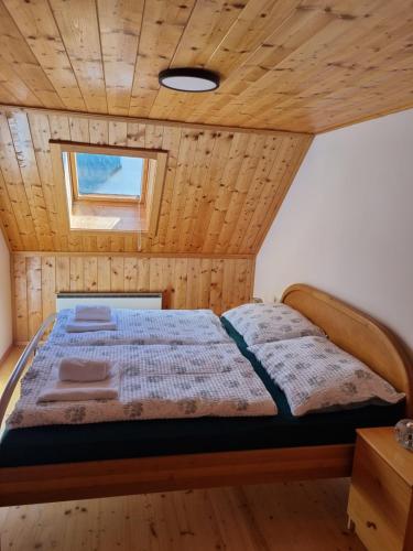 a bed in a room with a wooden ceiling at S-apartment Wiedweg in Wiedweg