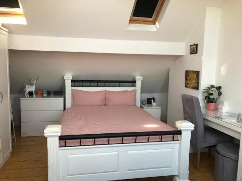 a bedroom with a white bed with a pink pillow at Sabrinas Studio BB&B in Bristol