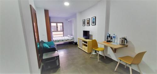 a living room with a desk and chairs in a room at Lala Loft Las Canteras in Las Palmas de Gran Canaria