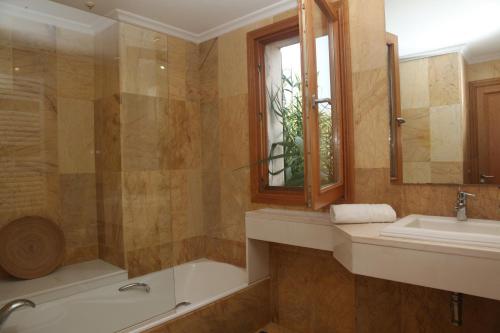 a bathroom with a tub and a sink and a shower at Villa Can Jaume in Can Picafort