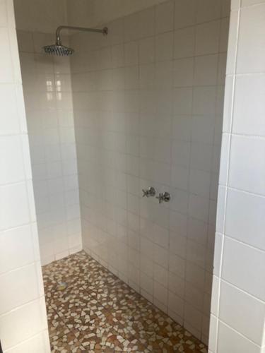 a bathroom with a shower with a tile floor at 3 ALOES GUESTHOUSE in Uis