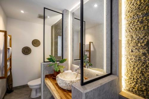 a bathroom with a sink and a toilet at La Jungle Villa in Ubud