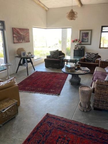 a living room with couches and rugs on the floor at 3 ALOES GUESTHOUSE in Uis