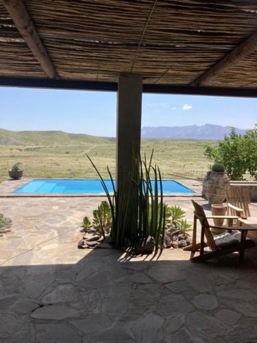 a person sitting in a chair on a patio at 3 ALOES GUESTHOUSE in Uis