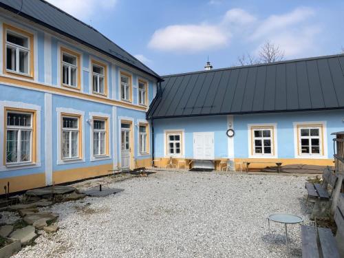 un gran edificio azul con muchas ventanas en Hostinec u Klačkov, 