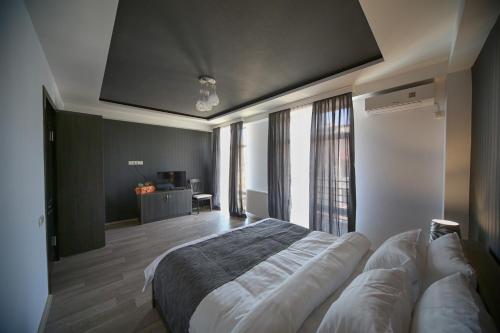 a bedroom with a large bed and a large window at Continental Hotel in Kutaisi
