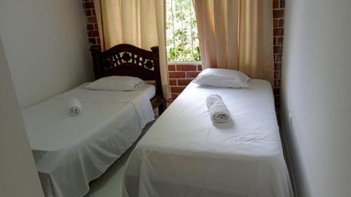 two twin beds in a room with a window at Apartamento Amoblado en Ibagué in Ibagué