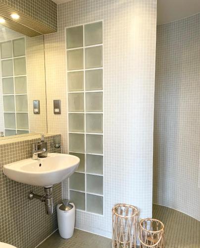 a bathroom with a sink and a mirror and some chairs at Edinburgh Penthouse 101 in Edinburgh