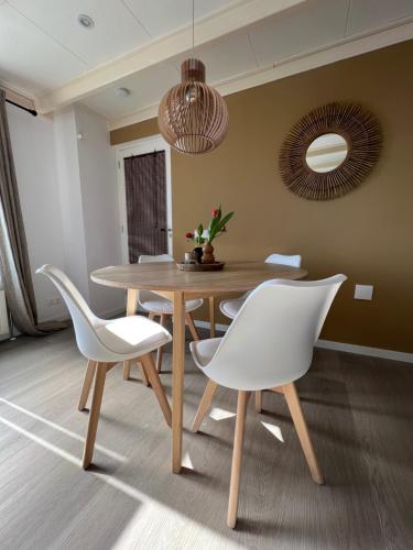 a dining room with a wooden table and white chairs at Mid83 in Woudsend