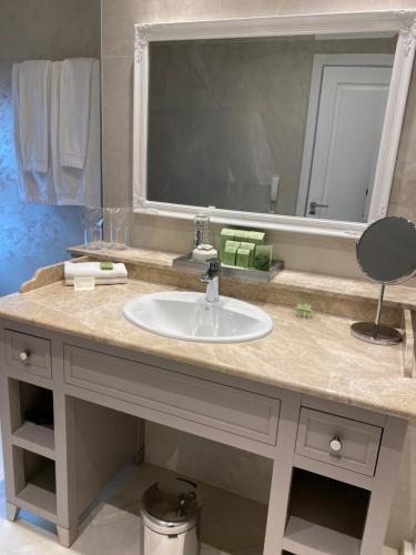 a bathroom with a sink and a large mirror at Villa Promenade in Burgas City