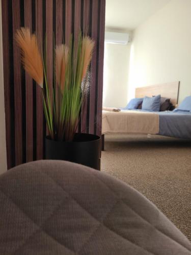 a bedroom with a bed and a vase with flowers at Stari Zaječar apartments in Zaječar