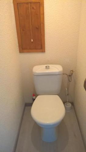 La salle de bains est pourvue de toilettes blanches et d'une armoire en bois. dans l'établissement APPARTEMENT PRAZ VILLAGE, à Praz-sur-Arly