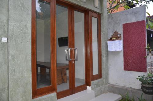 a wooden door to a room with a table at Shreya Guest House in Ubud