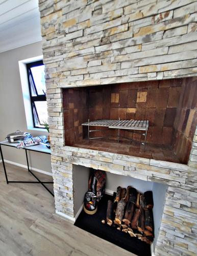 a stone fireplace in a living room at Sea you on Sands in Wilderness