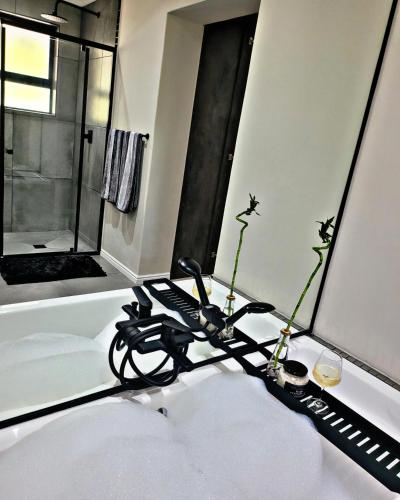 a bathroom with a bath tub with a black object on a table at Sea you on Sands in Wilderness