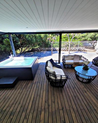 a deck with a hot tub and a table and chairs at Sea you on Sands in Wilderness