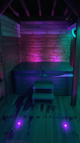 a room with a bench in a room with purple lights at Les Lodges de Malendure in Bouillante
