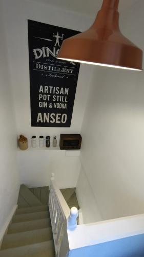 a staircase in a house with a sign on the wall at 1780 Green Street in Dingle