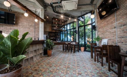 un restaurante con mesas, sillas y ventanas en โรงแรม บอร์ดดิ้งเฮ้าส์, en Ban Bang Yai Chuai